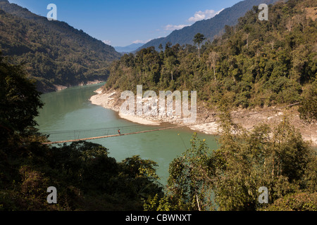 L'Inde, de l'Arunachal Pradesh, Panging village, femme marche sur l'ensemble du pont suspendu de la rivière Digang contreforts de l'Himalaya dans Banque D'Images