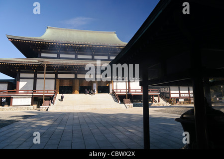 NARITA, Japon — la grande salle principale du temple Naritasan Shinshoji, également connu sous le nom de Shinsho-Ji, avec des brins de fumée d'encens dérivant à travers le cadre. Cette structure centrale de l'ancien complexe bouddhiste Shingon, établi en 940 après JC, présente l'architecture traditionnelle japonaise des temples et la pratique continue de brûler de l'encens dans le cadre des rituels bouddhistes. Banque D'Images