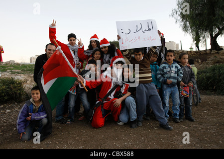 Les Arabes et les Palestiniens israéliens dans les tenues du Père Noël détiennent le drapeau de Palestini9an alors qu'ils posent pour un photographe lors d'une manifestation contre l'occupation israélienne et les activités de colonisation dans le quartier de Sheikh Jarrah à Jérusalem-est, en Israël.Le quartier palestinien de Sheikh Jarrah est actuellement au centre d'un certain nombre de conflits de propriété entre Palestiniens et Israéliens juifs de droite.Certaines maisons ont été occupées par des colons israéliens à la suite d'une décision du tribunal. Banque D'Images