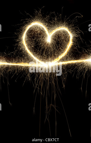 Forme de coeur fait avec sparkler la nuit.