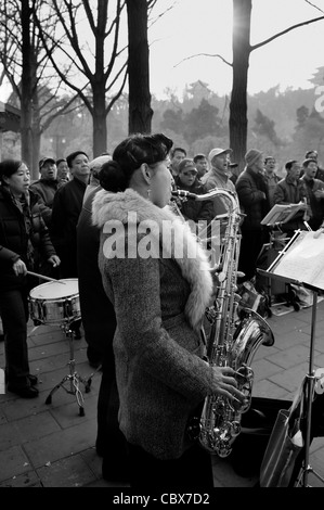 Beijing, Parc Jingshan. Les gens jouer de la musique dans le parc avec le saxophoniste dans l'avant-plan. Banque D'Images