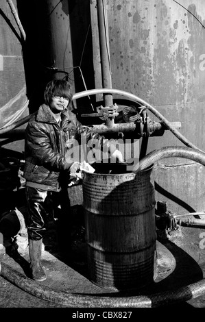 DongBaXiang, Beijing. Jeune homme travaillant dans une usine de recyclage de l'huile de cuisson. Banque D'Images