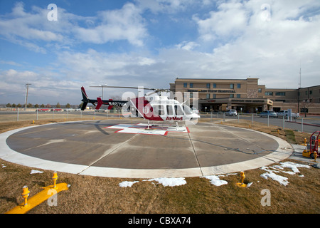 AirMed hélicoptère du Centre médical de l'Université de l'Utah prêt pour vol d'urgence en face d'un petit hôpital. Hélisurface. Banque D'Images