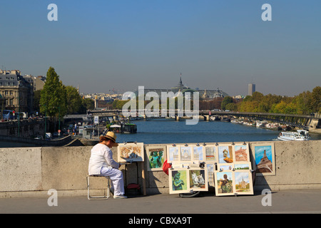 Un artiste affiche son travail sur un pont sur la Seine, Paris. Banque D'Images