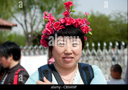 Beijing, Parc Yuyuantan (Jade Lake Park). Femme portant une guirlande de fleurs. Banque D'Images