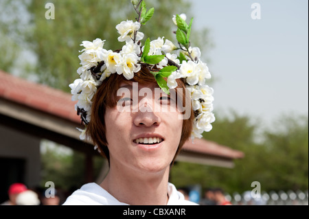 Beijing, Parc Yuyuantan (Jade Lake Park). Homme portant une guirlande de fleurs. Banque D'Images