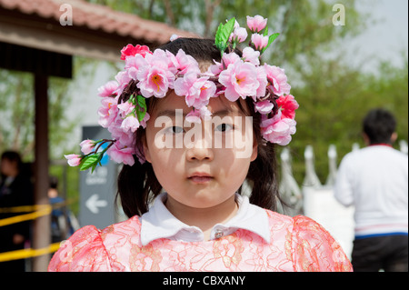 Beijing, Parc Yuyuantan (Jade Lake Park). Jeune fille portant une guirlande de fleurs. Banque D'Images