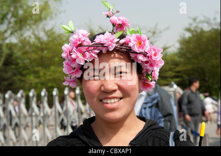 Beijing, Parc Yuyuantan (Jade Lake Park). Femme portant une guirlande de fleurs. Banque D'Images