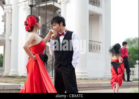 Beijing, Parc de Chaoyang. Worker carrying garbage en passant une photo de mariage tournage. Banque D'Images