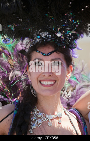 Femme en coiffe à plumes et rhinestone necklace participe au carnaval annuel de Mission District, San Francisco, Californie Banque D'Images