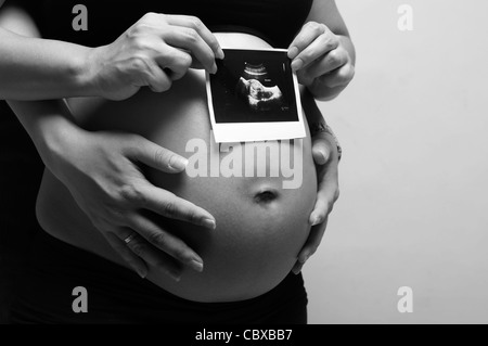 Une photo d'une femme enceinte avec mari holding échographie de l'enfant à naître Banque D'Images