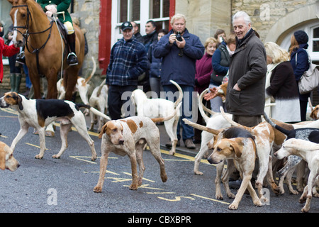 Fox Hounds menée par le village de Chipping Norton par le maître de la chasse sur un cheval pour le boxing day rencontrez Banque D'Images