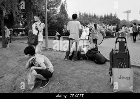 Parc de Chaoyang, Beijing. Les visiteurs dans le dos avec en arrière-plan une photo de mariage tournage. Banque D'Images