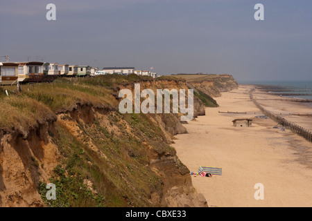 Littoral Happisburgh, North Norfolk, l'East Anglia. Caravanes avec vue sur la mer du Nord à partir de la falaise. Les défenses de la mer le long du littoral. Banque D'Images