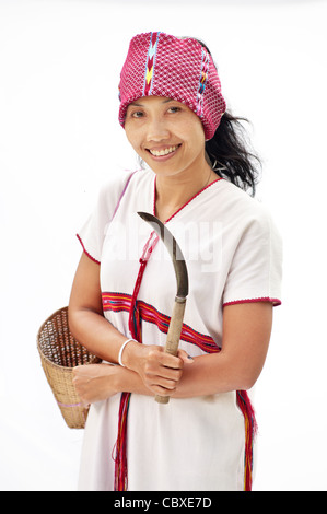 Une femme portant l'habit traditionnel pour une femme non mariée Karen et tenant un couteau utilisé pour la récolte du riz. Banque D'Images