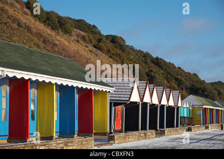 Cabines de plage le long de la promenade de Bournemouth avec un saupoudrage de neige sur une journée d'hiver ensoleillée en Décembre Banque D'Images
