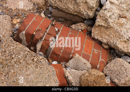 Littoral Happisburgh, North Norfolk, l'East Anglia. L'érosion des falaises par des maisons sur la mer du Nord. Mur de brique, béton démoli. Banque D'Images