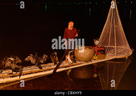 Pêcheur chinois avec les oiseaux et de cormorans sur net un radeau en bambou dans Yangshuo Chine dans la nuit sur la rivière Li Banque D'Images