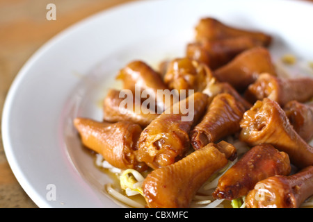 Cuisse de poulet à l'étuvée avec les germes de soja sur une assiette blanche. Banque D'Images
