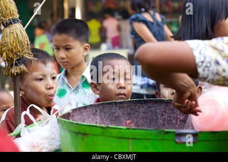 Les jeunes enfants non identifiés d'oeil sur le coton candy est en train de provoquer à Bagan, Myanmar Banque D'Images