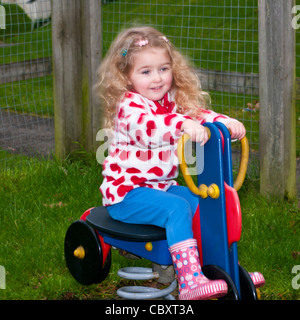 Enfant de 3 ans enfant fille enfant jouant sur une aire de jeux pour rouler avec flou de mouvement intentionnel Banque D'Images