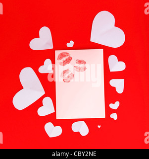 Carte vierge avec des baisers rouge isolé sur fond rouge, conceptual image d'amour et de la Saint-Valentin Banque D'Images