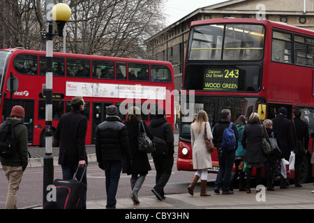 Une file de gens qui attendent à bord d'un bus rouge de Londres Banque D'Images