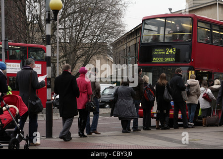 Une file de gens qui attendent à bord d'un bus rouge de Londres Banque D'Images