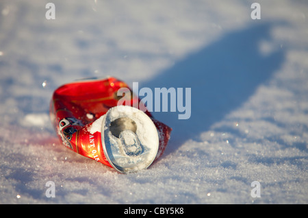 Un gros plan isolé d'une bière rouge écrasée peut être couché sur le sol sur la neige à Winter, Finlande Banque D'Images