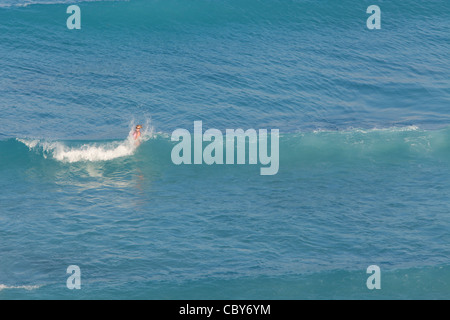 Femme d'être éclaboussé par une vague bleue à Cancun au Mexique Banque D'Images