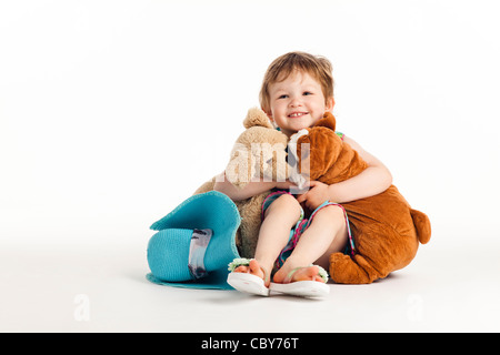 Heureux l'enfant serrant ses animaux en peluche Banque D'Images