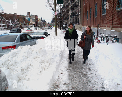 Deux jeunes femmes marchant après neige, Metropolitan Avenue, Brooklyn, New York Banque D'Images