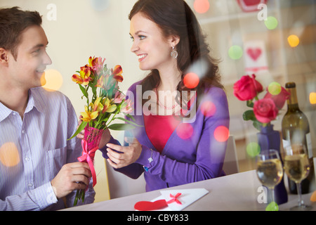 Un jeune homme donnant à bouquet floral à la jolie petite amie Banque D'Images