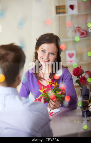 Un jeune homme donnant à bouquet de fleurs à la jolie petite amie Banque D'Images