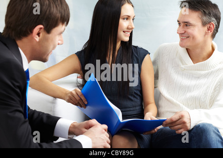 Portrait de couple moderne discuter conditions du prêt hypothécaire avec agent immobilier près de par Banque D'Images