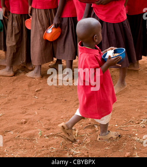 Un enfant dans une école du Kenya porte son passé déjeuner dîner la file d'attente à l'école primaire Easfield Kileva près de Voi Banque D'Images