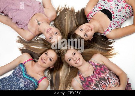 Vue de dessus de quatre adolescentes couché sur marbre blanc. Banque D'Images