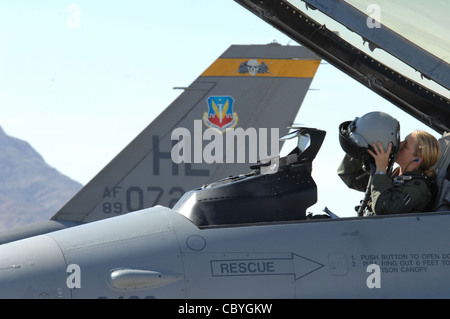 Le capitaine Jennifer Wade met son casque de vol le 22 juillet avant une mission d'entraînement pendant le drapeau rouge à la base aérienne de Nellis, au Nevada. Le capitaine Wade est un pilote de faucon F-16 affecté à Hill AFB, en Utah. Banque D'Images