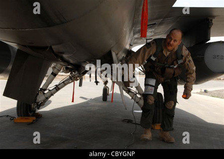 Le Maj Dag Grantham, 332e Escadron de chasseurs expéditionnaires F-16, pilote Faucon Fighting à la base aérienne de Balad, en Irak, effectue une inspection avant vol de son aéronef avant une mission. L'inspection avant vol comprend la vérification de tous les panneaux d'entretien pour s'assurer qu'ils sont fermés et que les bouchons du réservoir de carburant sont bien fixés. Le F-16 est un avion de chasse multirôle compact, extrêmement maniable et qui s'est révélé efficace dans les combats aériens et les attaques air-surface. Le major Grantham est déployé à partir de la base aérienne de Luke, en Arizona. Banque D'Images