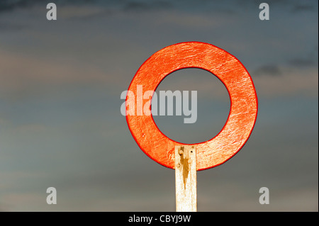 Finition en cercle rouge post soleil contre un ciel d'orage Banque D'Images