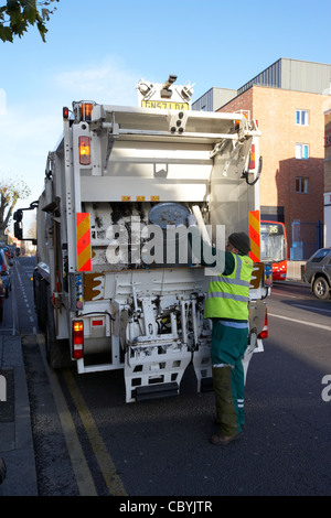 Travailleur veolia travaillant au nom du conseil local de collecte des déchets brent refuser dans un camion benne london uk united kingdom Banque D'Images