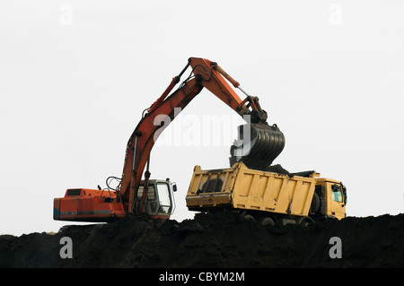 Chargement camion excavateur. Isolé blanc Banque D'Images