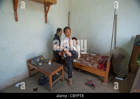 Pauvre mère vietnamienne portant son enfant handicapé, un adolescent handicapé (Vietnam) Banque D'Images