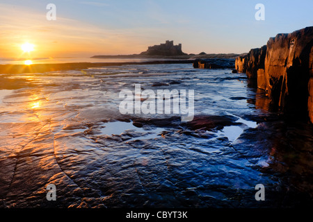 Lever du soleil près de Château de Bamburgh sur la côte nord-est de l'Angleterre Banque D'Images