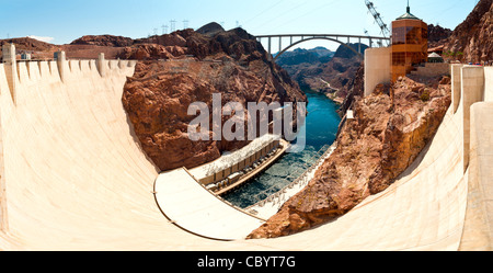 Vue panoramique tourné prise depuis le sommet du mur de béton du barrage de Hoover à la bas, en direction de l'usine d'énergie hydroélectrique et la Colorando rivière qui coule entre les rocky clifs. Il est repris de Nevada à côté vers le côté de l'Arizona. Banque D'Images