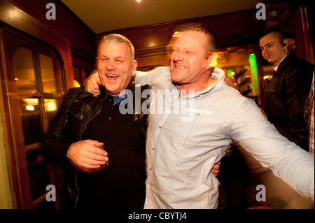 Deux hommes rire célébrant la nouvelle année 2012, dans les rues d'Aberystwyth, Pays de Galles UK Banque D'Images