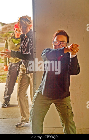 Se tenant la main où ils tiendraient une arme de poing, les femmes agents d'application de la pratique de la saisie d'un prix au centre de formation. Banque D'Images