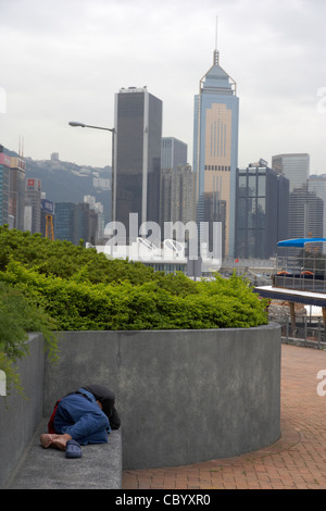 L'homme chinois en plein air à dormir sur un banc de parc en Causeway Bay Hong Kong Hong Kong Chine Asie Banque D'Images