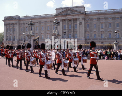Des foules de gens à la cérémonie de changement de garde régiment de gardes britanniques Musiciens marchant en uniforme de cérémonie au Buckingham Palace Londres Angleterre ROYAUME-UNI Banque D'Images