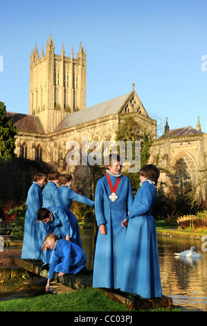 Les choristes du garçon Wells Cathedral Choir dans Somerset UK de prendre une pause de répétitions par 'l'étang des puits après lequel le ci Banque D'Images